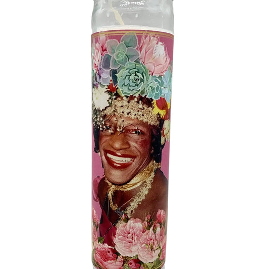 Candle with a colorful design featuring a smiling person and flowers on a white background