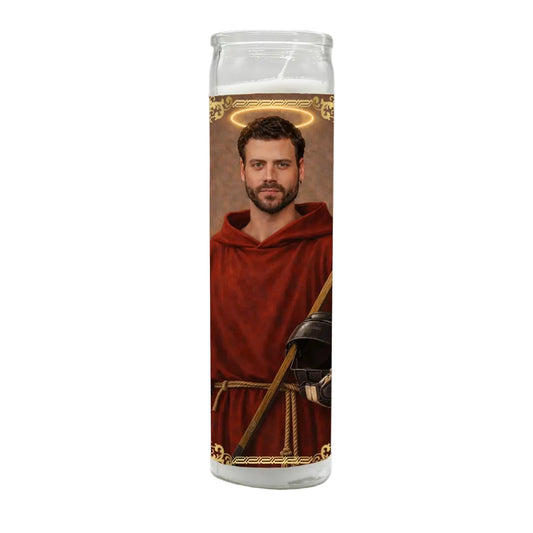 Candle with a printed design of a person in a red robe and helmet on a white background