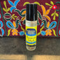 Perfume oil bottle labeled 'Egyptian Musk' by Moonlight Rose on a textured surface with a colorful embroidered fabric background.